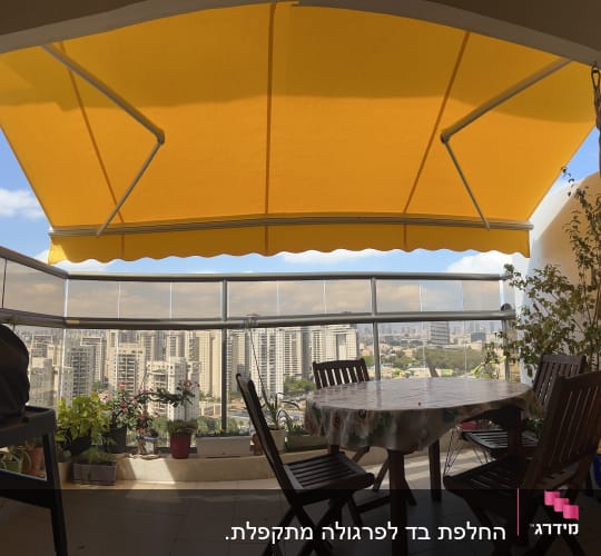 סוכך צהוב גדול במרפסת עם נוף עירוני